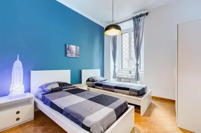 two beds in a bedroom with blue walls at Colors & Culture near Colosseum in Rome