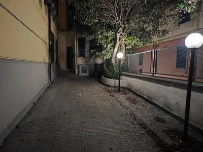 an empty alley with two street lights next to a building at Brando Apartment in Rome