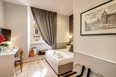 a small hotel room with a bed and a desk at TLV Navona in Rome