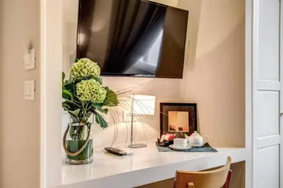 a vase of flowers on a shelf with a mirror at TLV Navona in Rome