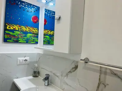a white bathroom with a sink and a mirror at Suite San Damaso in Rome