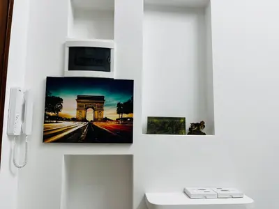 a wall with three pictures of a monument and a phone at Suite San Damaso in Rome