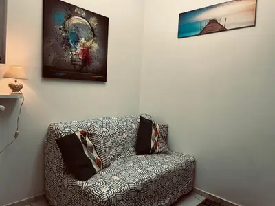 a living room with a couch and a painting on the wall at Suite San Damaso in Rome