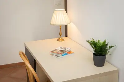 a table with a lamp and a book on it at Turati by Rental in Rome in Rome