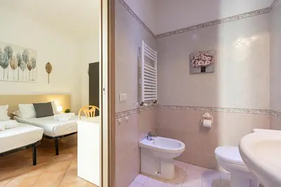 a bathroom with a toilet and a sink and a bed at Turati by Rental in Rome in Rome