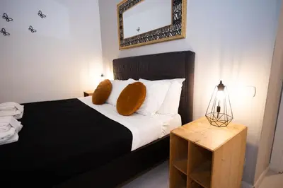 a bedroom with a bed with pillows and a mirror at Persia Collection Colosseo in Rome