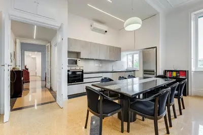a kitchen with a black table and black chairs at BMGA l Elegant Four-Room Apt for 8 Guests in Prati in Rome