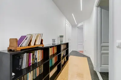 a book shelf filled with books in a hallway at BMGA l Elegant Four-Room Apt for 8 Guests in Prati in Rome