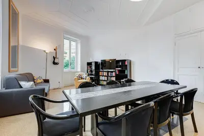 a living room with a dining room table and chairs at BMGA l Elegant Four-Room Apt for 8 Guests in Prati in Rome