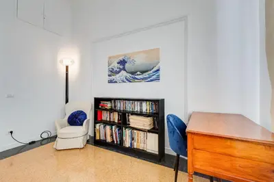 a room with a desk and a book shelf with dvds at BMGA l Elegant Four-Room Apt for 8 Guests in Prati in Rome