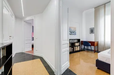 a white room with a bed and a desk at BMGA l Elegant Four-Room Apt for 8 Guests in Prati in Rome