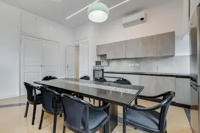 a dining room with a black table and black chairs at BMGA l Elegant Four-Room Apt for 8 Guests in Prati in Rome