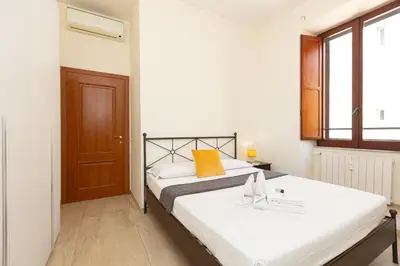 a bedroom with a white bed with a wooden door at Vatican Museum by Rental in Rome in Rome