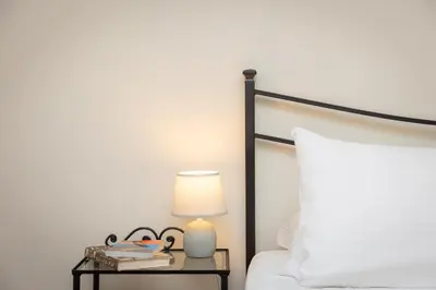 a bed with a nightstand with a lamp and a white pillow at Vatican Museum by Rental in Rome in Rome