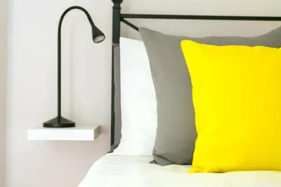 a bed with a yellow pillow and a lamp at Monti Colosseum in Rome