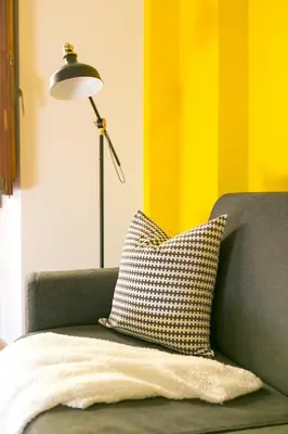 a pillow sitting on a couch next to a lamp at Monti Colosseum in Rome