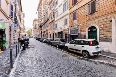 a cobblestone street with parked cars and buildings at Monti Colosseum in Rome