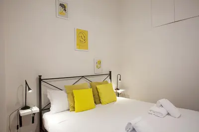 a bedroom with a white bed with yellow pillows at Monti Colosseum in Rome
