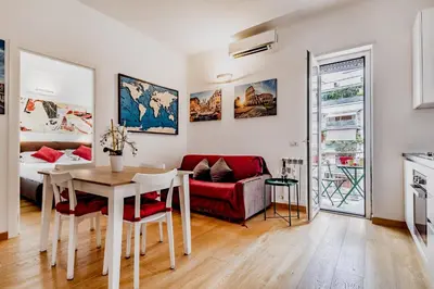 a living room with a table and a red couch at BBHOME Elegant apartment at Saint Peter front of Vatican in Rome