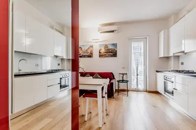 a kitchen and a dining room with white cabinets at BBHOME Elegant apartment at Saint Peter front of Vatican in Rome