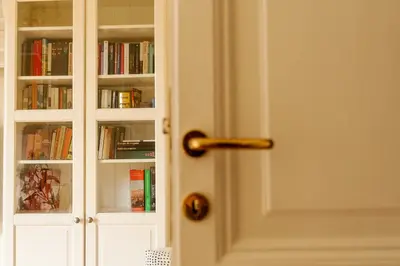a white door with books in it at Borghese Magnolia Suite in Rome