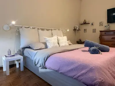 a bedroom with a large bed and a table at Cozy flat with terrace at Trastevere train station in Rome