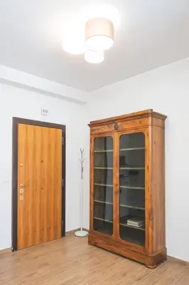 a wooden cabinet in a room next to a door at Cozy flat with terrace at Trastevere train station in Rome