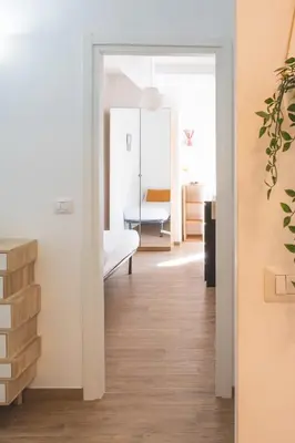 a hallway with a room with a bed and a mirror at Cozy flat with terrace at Trastevere train station in Rome
