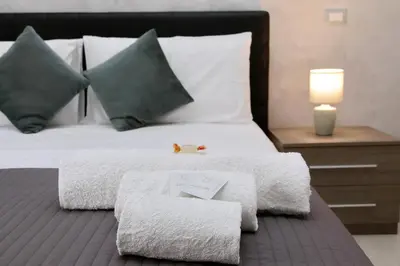 a bed with a pile of towels on top of it at Domus Gallo Guest House in Rome
