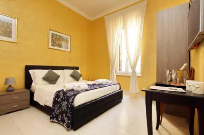 a bedroom with a bed and a desk and a window at Domus Gallo Guest House in Rome