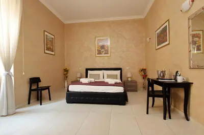 a bedroom with a bed and a table and a desk at Domus Gallo Guest House in Rome