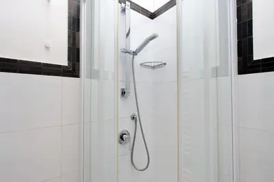 a shower in a bathroom with white tiles at Domus Gallo Guest House in Rome
