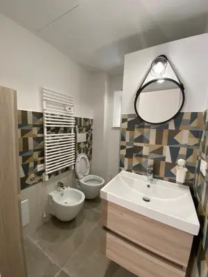 a bathroom with a sink and a toilet and a mirror at Laura Apartment in Rome