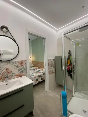 a bathroom with a sink and a shower and a bed at Laura Apartment in Rome