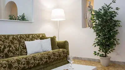 a living room with a couch and a potted plant at Atheneum by Rental in Rome in Rome