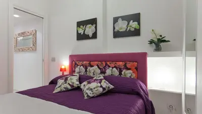 a bedroom with a purple bed with two pillows at Consulta By Rental In Rome in Rome