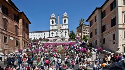 a crowd of people walking down a street with a church at Circo Massimo Apartment 2 in Rome
