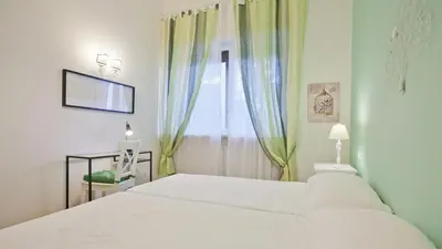 a bedroom with a white bed and a window at Circo Massimo Apartment 2 in Rome