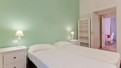 a bedroom with a large white bed with two lamps at Circo Massimo Apartment 2 in Rome
