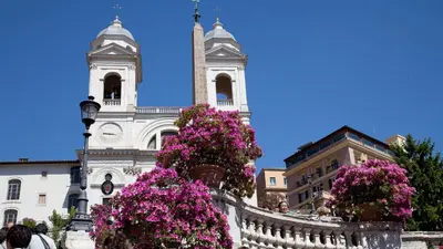 a building with a clock tower and flowers in front of it at Circo Massimo Apartment 2 in Rome