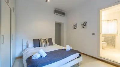 a white bedroom with a bed and a mirror at Rental in Rome Purificazione apartament in Rome