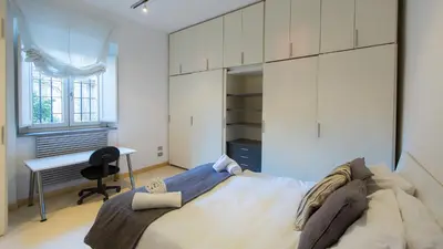 a bedroom with a large bed and a desk at Rental in Rome Purificazione apartament in Rome