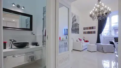 a white bathroom with a sink and a chandelier at Quirinale by Rental in Rome in Rome