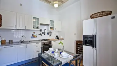 a white kitchen with a table and a refrigerator at Rental in Rome Trevi Fouintain View Apartment in Rome