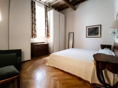 a bedroom with a white bed and a chair at Raffaello Terrace - near Piazza Navona in Rome
