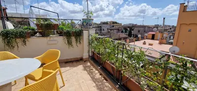 a balcony with a table and chairs and a view of a city at Raffaello Terrace - near Piazza Navona in Rome