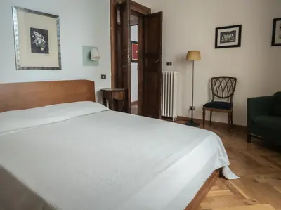 a bedroom with a white bed and a chair at Raffaello Terrace - near Piazza Navona in Rome