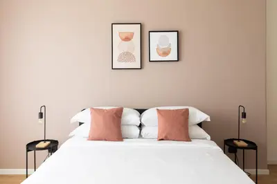 a bedroom with a white bed with two pictures on the wall at [Ampio appartamento vicino al Vaticano] in Rome