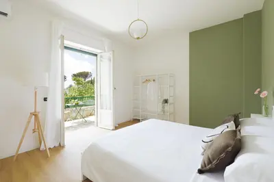 a bedroom with a white bed and a large window at [Ampio appartamento vicino al Vaticano] in Rome