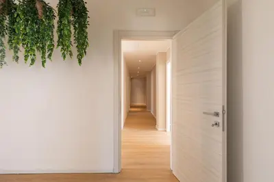a hallway with a white door and a plant at [Ampio appartamento vicino al Vaticano] in Rome